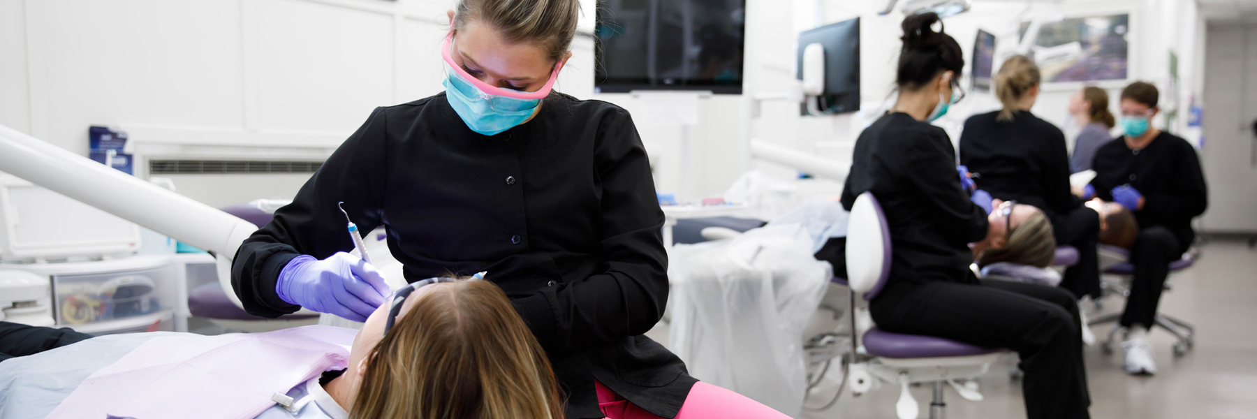 A dental hygiene student practices their technique on a patient.